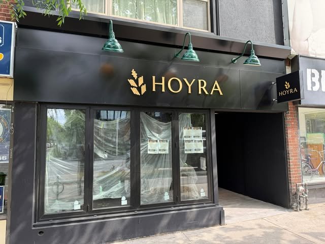 New dark storefront fascia with gold HOYRA lettering and hanging lamps
