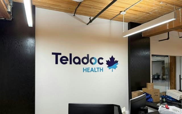 Custom dimensional reception-wall signage in an office interior