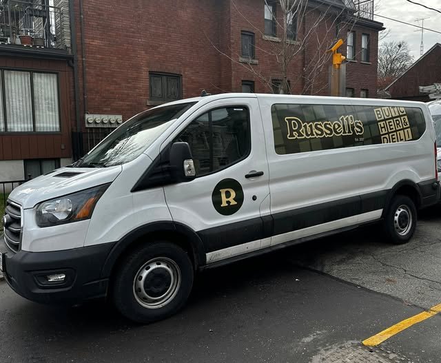 White cargo van with gold vinyl Russell's branding and R logo decal