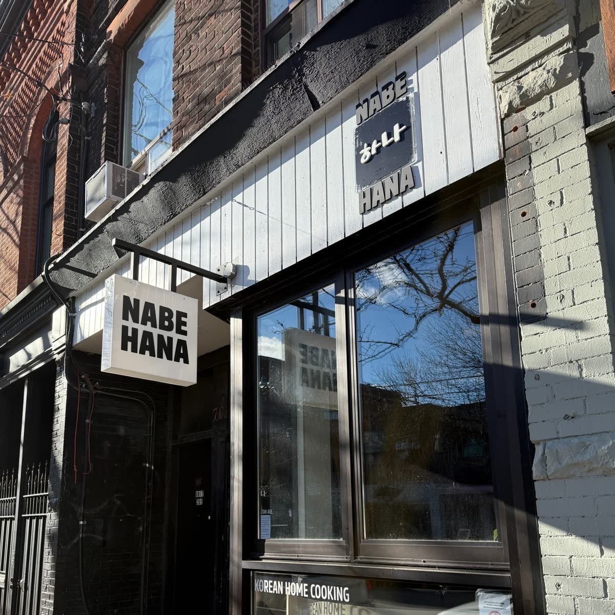 Hanging blade sign and dimensional letters on a restaurant storefront
