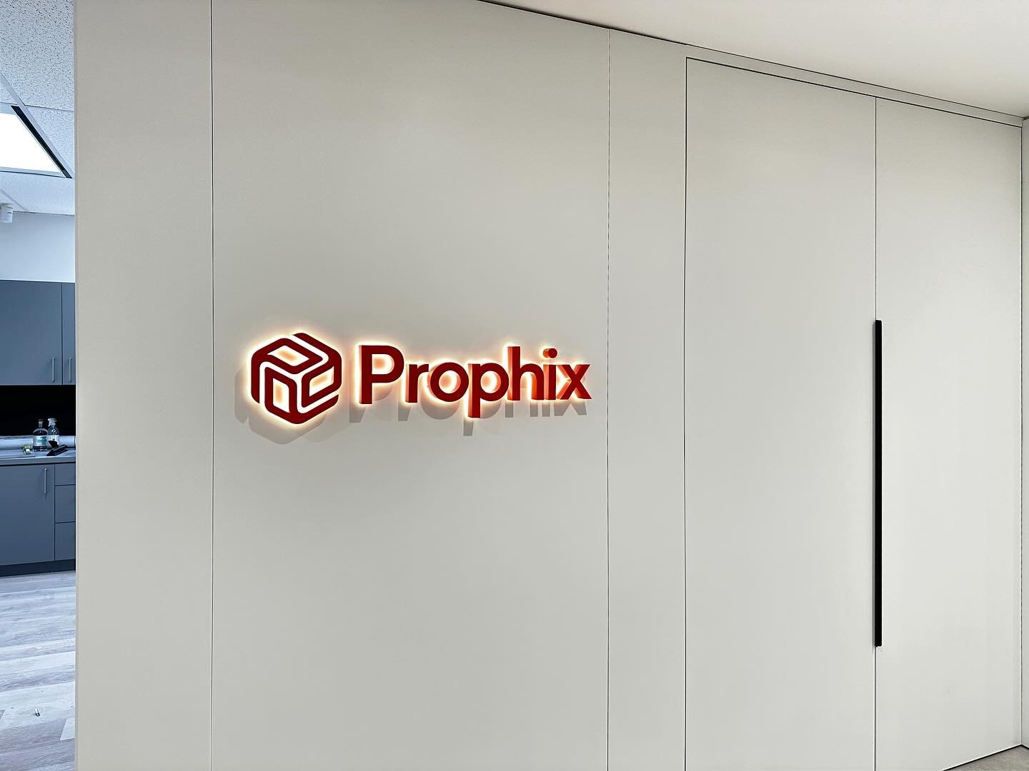 Interior office wall with halo-lit fabricated letters and printed mural