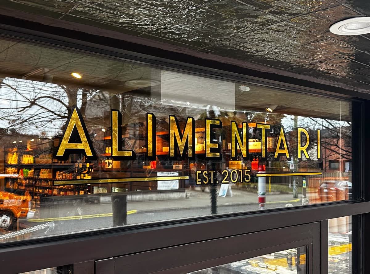 Gold window vinyl lettering across a shop front window